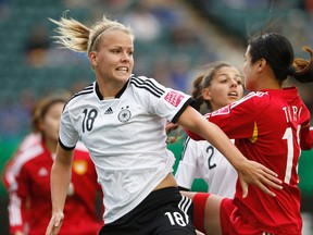 Germany's Lena Petermann (18) battles China's Ruyin Tan (14) during the first half of FIFA U-20 Women's World Cup play at Commonwealth Stadium in Edmonton Alta., on Friday Aug. 8, 2014. Ian Kucerak/Edmonton Sun/ QMI Agency