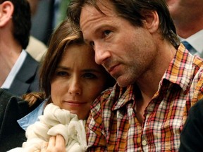 Actor David Duchovny sits with his wife, actress Tea Leoni, as they watch former world number one Andre Agassi and 14-time grand slam champion Pete Sampras play their exhibition match at the BNP Paribas Showdown at Madison Square Garden in New York February 28, 2011.  REUTERS/Mike Segar