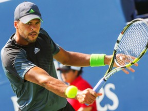 Jo-Wilfried Tsonga hits a return against Grigor Dimitrov during their Rogers Cup semifinal match in Toronto, Aug. 9, 2014. (DAVE THOMAS/QMI Agency)