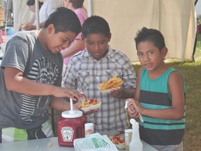 Daniel, Angel, and Alex Marroquin put condiments on their free fries at the Portage Potato Festival Aug. 9. (Kevin Hirschfield/The Graphic/QMI AGENCY)