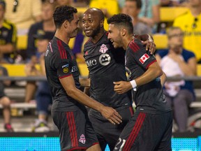 Toronto FC midfielder Jonathan Osorio (21) celebrates his goal with forward Gilberto (9) and midfielder Collen Warner (26) in the second half at Crew Stadium on Aug. 10. (USA Today Sports)