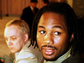 Boxer Lennox Lewis poses at a press conference in New York December 18, 1996 with Frank Maloney in the background. (Reuters file photo)