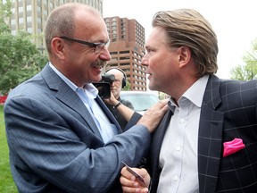 Lightest moment on a serious day. Alberta PC Leadership candidates Ric McIver (left) and Thomas Lukaszuk shake hands and exchange business cards between speaking to reporters, after Alberta's Auditor General released his August 2014 Special Duty Report of Premier Redford and Alberta's Air Transportation Services Program, at the Alberta Legislature in Edmonton Alta., on Thursday Aug. 7, 2014. Lukaszuk walked into McIver's press conference in front of the Federal Building, a key spot in the Redford saga.  David Bloom/Edmonton Sun/QMI Agency