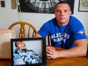 Flanked by his late step-brother Joseph Pazner's ashes and portrait, Rob Ouellette talks about spreading a some of his late stepbrother's ashes at the Rogers Centre last Friday night. (MIKE HENSEN, QMI Agency)