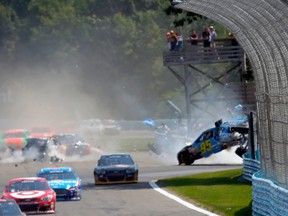 Michael McDowell, driver of the #95 K-Love Ford, crashes into the wall at the  Sprint Cup Series Cheez-It 355 at Watkins Glen International yesterday. (AFP)