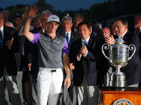 Rory McIlroy of Northern Ireland celebrates with PGA officials when presented with the Wanamaker Trophy after winning the 2014 PGA Championship at Valhalla Golf Club in Louisville, Kentucky, August 10, 2014. (REUTERS)