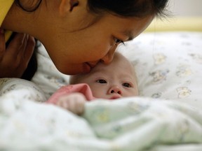 Gammy, a baby born with Down's Syndrome, is kissed by his surrogate mother Pattaramon Janbua at a hospital in Chonburi province on August 3, 2014. (REUTERS/Damir Sagolj)