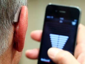 An employee of GN, the world's fourth largest maker of hearing aids, demonstrates the use of ReSound LiNX in Vienna Nov. 22, 2013.  REUTERS/Heinz-Peter Bader