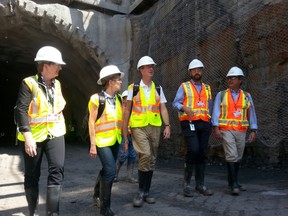 Deputy city manager Nancy Schepers, Premier Kathleen Wynne and Mayor Jim Watson talk with experts from the Rideau Transit Group as they walk out of the LRT tunnel portal off Albert St. on Monday, Aug. 11, 2014 (Jon Willing/Ottawa Sun)