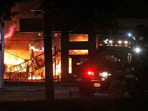 A QuikTrip convenience store burns during a night of rioting in Ferguson, Missouri August 10, 2014. Police arrested 32 people after rioting and looting erupted in Ferguson, Missouri, late on Sunday and spread to neighboring towns in protests that turned violent over the killing of a black teenager by a police officer, officials said on Monday. Picture taken August 10, 2014.  REUTERS/Robert Cohen/St. Louis Post-Dispatch/MCT