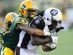 Dexter McCoil wraps up Ottawa's Chevon Walker during a game earlier this season at Commonwealth Stadium. (Reuters)