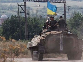 Ukrainian servicemen ride atop an armoured personnel carrier (APC) as they patrol an area near Donetsk August 11, 2014. REUTERS/Valentyn Ogirenko