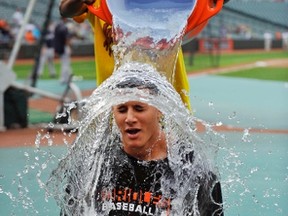 Baltimore Orioles outfielder (rear) pours a bucket of ice water on third baseman Manny Machado (seated) as part of the ALS ice bucket challenge prior to a game against the New York Yankees at Oriole Park at Camden Yards. (Joy R. Absalon-USA TODAY Sports)