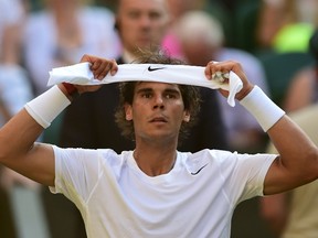 Spain's Rafael Nadal adjusts his headband between sets during his men's singles fourth round match against Australia's Nick Kyrgios on day eight of the 2014 Wimbledon Championships at The All England Tennis Club in Wimbledon, southwest London, on July 1, 2014. (AFP PHOTO / CARL COURT)