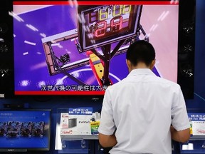 A man plays with Sony Corp's PlayStation 4 console at an electronics retail store in Tokyo July 16, 2014. REUTERS/Yuya Shino