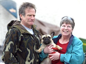 Actor Robin Williams makes a face while entertaining Marion Anderson's pet French bulldog Fleur on Sat., May 22, 2004 near the film set of 'The Big White' on Burrows Avenue. Anderson was one of many fans Williams greeted between takes.