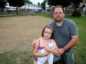 Brad Boxell and his daughter Evelynne, 8, in Kingston were among those concerned the recently torn down play structure behind their Compton Street housing complex would not be replaced. (Ian MacAlpine/Whig-Standard file photo)