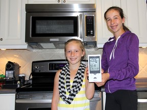 Lauren Matesic, 9, left, and her sister Morgan, 14, can find out how much electricity is being used in their Chatham home thanks to this wireless monitor provided through the peaksaver PLUS program, offered to Entegrus customers. The municipal-owned utility is encouraging customers to take advantage of this free program, which includes a monitor from Blue Line Innovations Inc. (ELLWOOD SHREVE  ellwood.shreve@sunmedia.ca)