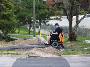 Charles Seed passes through a construction area over an asphalt ramp on Belmont Road in London, Ontario on Friday, August 8, 2014.  DEREK RUTTAN/ The London Free Press /QMI AGENCY