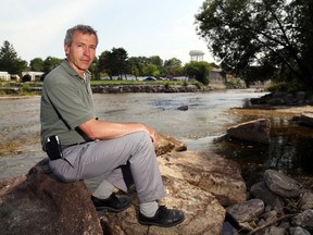 Quinte Conservation's Bryon Keene sits on a rock in the Moira River in Belleville, Ont. Monday, August 11, 2014. He says reducing nutrients that cause toxic algae growth is "a community decision," requiring action by all. Luke Hendry/The Intelligencer/QMI Agency