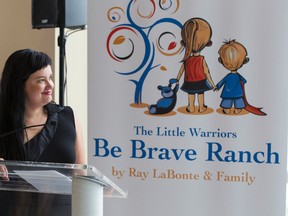 Glori Meldrum, founder of Little Warriors, unveils new print ads at the launch of the organization's 2014 campaign at Alberta Honda in Edmonton, Alta., on Tuesday, Aug. 12, 2014. The organization helps young victims of sexual abuse and is about to open the Be Brave Ranch, a treatment facility. Ian Kucerak/Edmonton Sun/QMI Agency