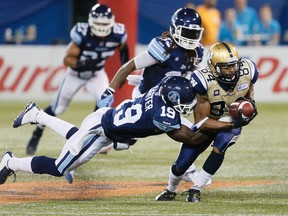 Romby Bryant gets tackled by Jalil Carter as the Toronto Argonauts beat the Winnipeg Blue Bombers  38-21 in  CFL action tonight at the Rogers Centre in Toronto, Ont. on Tuesday August 12, 2014. Stan Behal/Toronto Sun/QMI Agency