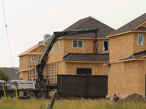 Drywall is delivered to the second floor of a home under construction in a new subdivision near Sarnia Road and Hyde Park Road in London, Ont. on Monday July 14, 2014. (MIKE HENSEN/The London Free Press/Postmedia Network file photo)