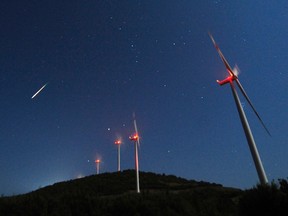 A meteor streaks across the sky during the Perseid meteor shower at a windmill farm near Bogdanci, south of Skopje, in the early morning August 13, 2014. REUTERS/Ognen Teofilovski