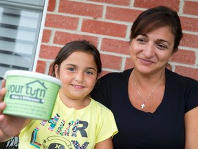 Lisa Chirico and her daughter Marissa, 7, show the kitchen grease container given to them by the city in a pilot project aimed at reducing the amount of cooking oils and greases flushed into the sewer systems. (CRAIG GLOVER, The London Free Press)