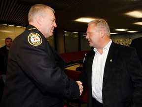 Councillor Doug Ford, right, shakes Toronto Police Chief Bill Blair's hand after the chief presented his budget to the budget committee January 14, 2011. (Craig Robertson/Toronto Sun)