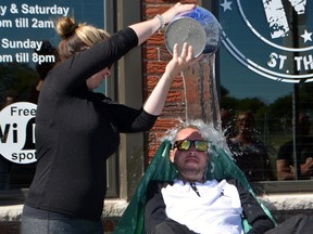 Megan McTaggart dumped a pail of cold icewater on the head of her brother, Steve Barber, as part of the ALS Challenge Wednesday outside the Midtown Tavern. 
Don Biggs/Times-Journal