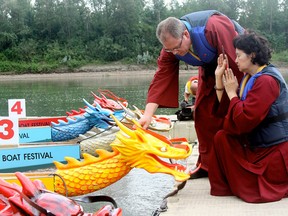 Buddhist monks Dharma instructor Robert Rosinki (back), Master Lin Ho do a traditional blessing of the boats and painting eyes on the dragon boats to awaken the dragon spirits at the start of the 18th Annual Dragon Boating Festival at the Louise McKinney Park on Wednesday in Edmonton. The festival runs from August 15-17th. (HUGO SANCHEZ/Special to the Edmonton Sun)