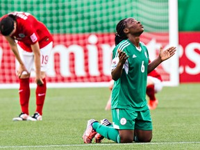 England's Abbey-Leigh Stringer reacts to her team's loss as Nigeria's Sarah Nnodim appears to pray during FIFA U-20 Women's World Cup action between Paraguay and England at Commonwealth Stadium in Edmonton, Alta., on Wednesday, Aug. 13, 2014. Codie McLachlan/Edmonton Sun/QMI Agency