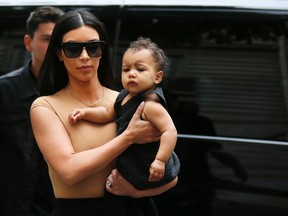 TV personality Kim Kardashian holds her daughter North in her arms as she shops in Paris May 20, 2014. U.S. television personality Kim Kardashian and rapper Kanye West will celebrate their wedding in Florence on May 24, an official from the mayor's office confirmed on Friday. (REUTERS/Gonzalo Fuentes)