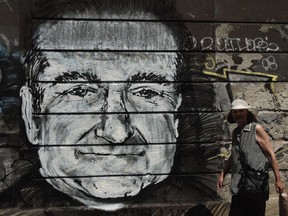 A woman walks past a mural depicting actor Robin Williams in downtown Belgrade on Wednesday. Unknown artists drew the Academy Award-winning actor and comedian below a Belgrade bridge to pay a tribute following the news that he had been found dead of an apparent suicide at the age of 63. (Photo by AFP)