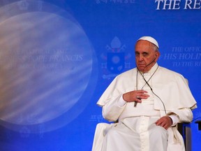 Pope Francis touches his cross while listening to South Korean President Park Geun-hye's speech during a news conference at the presidential Blue House in Seoul August 14, 2014. (REUTERS/Kim Hong-Ji)