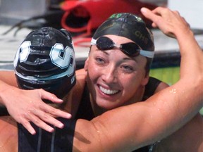 Amy Van Dyken (right) hugs Dara Torres after the two made the U.S. Olympic Swimming Team in the 50M freestyle in Indianapolis in this file photo taken Aug. 16, 2000. Van Dyken spent two months in a rehab facility after severing her spine when she crashed her all-terrain vehicle near her Arizona home. (Reuters/Files)