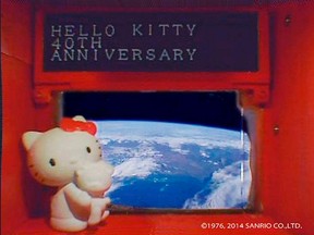 A 4-cm (1.6-inch) tall Hello Kitty figurine placed under a scrolling display in front of a window of the Hodoyoshi-3 satellite, is seen in what Sanrio Co. said is a still image from a video, made available to Reuters on August 14, 2014. (REUTERS/Sanrio Co. ,Ltd./Handout via Reuters)