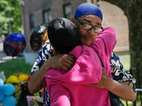 Nicholas Avitto, the father of 6-year-old Joshua "P.J " Avitto, is embraced outside makeshift memorial in the East New York section of the Brooklyn borough of New York June 4, 2014. REUTERS/Shannon Stapleton