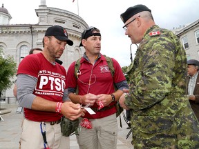Veterans Steve Hartwig, left, and Jason McKenzie, with Chief Warrant Officer Rob Markell, as they held a ceremony in Springer Market Square as part of their No Man's Land March through Kingston on Thursday. (Ian MacAlpine/The Whig-Standard)