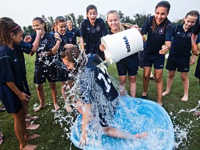 Hailey Casavant has a bucket of ice water dumped on her by teammate Sasha Gravel. Members of the 2001 Scottish United soccer team consisting of 12 and 13 year old girls took part in the Ice Bucket Challenge for ALS at the Edmonton Scottish Society in Edmonton, Alta., on Thursday, Aug. 14, 2014. The team took it a step further by issuing a challenge to the Canadian National U-20 Women's soccer team to do the same. Codie McLachlan/Edmonton Sun/QMI Agency