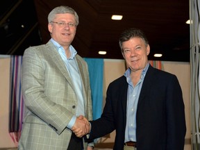 Prime Minister Stephen Harper, left, shakes hands with Colombia's President Juan Manuel Santos after closing ceremony in the VII Pacific Allianz Summit in Cali, May 23, 2013. (Andres Piscov/Colombian Presidency/Handout via Reuters)