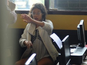 Heather Mack, the daughter of an American woman found dead inside a suitcase on the Indonesian holiday island of Bali, gestures while in custody in a police station in Denpasar on August 14, 2014. (REUTERS/Putu Setia)