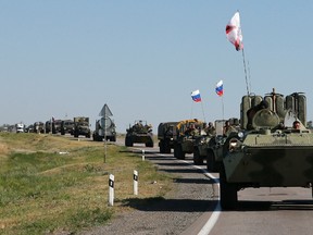 Russian military personnel ride atop armoured personnel carriers (APCs) outside Kamensk-Shakhtinsky, Rostov Region, August 15, 2014. (REUTERS/Maxim Shemetov)
