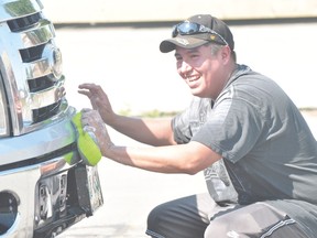 Bradley Smoke scrubs�the bumper of a truck during the Portage Friendship Centre's Day Camp/After School Program car wash/hot dog fundraiser Aug. 15. (Kevin Hirschfield/The Graphic)