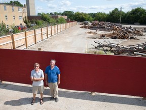 Ron Whitehead, left, and Jeffrey Blake stand in front of their Nelson St. apartment building, left, and debris from the former South St. hospital demolition, right. Neighbours are frustrated with the noise and dust from the demolition. (CRAIG GLOVER, The London Free Press)