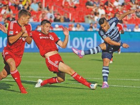 Toronto FC’s Nick Hagglund (left) and Bradley Orr attempt to block a shot by Sporting Kansas forward Dom Dwyer when the two teams met earlier this season. (USA TODAY SPORTS)