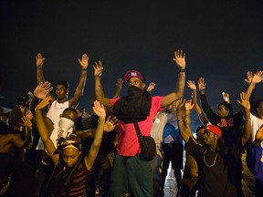 Demonstrators confront police with their arms raised during on-going demonstrations to protest against the shooting of Michael Brown, in Ferguson, Missouri, August 16, 2014. Protesters in Ferguson said late on Friday on Twitter that police had fired tear gas at a crowd protesting over the police shooting death of Brown, an unarmed black teen. The reported outbreak late Friday evening came after almost a week of nighttime clashes between local police and protesters saw a 24-hour break as those police forces were replaced by state police led by an African-American captain. REUTERS/Lucas Jackson
