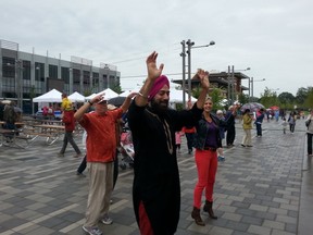 Kuljit Sodhi leads an impromptu dance lesson in the rain at Lansdowne Park's Aberdeen Square for its grand opening on Saturday, Aug. 16, 2014.
KELLY ROCHE/OTTAWA SUN/QMI AGENCY