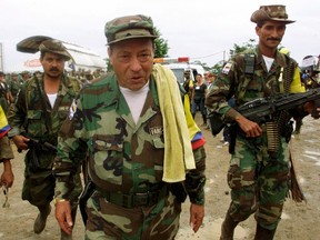 Colombian commander Manuel "Sureshot" Marulanda Velez (C) of the Revolutionary Armed Forces of Colombia (FARC) walks in Villa Colombia camp near San Vicente del Caguan, Caqueta province. REUTERS/Jose Miguel Gomez/Files